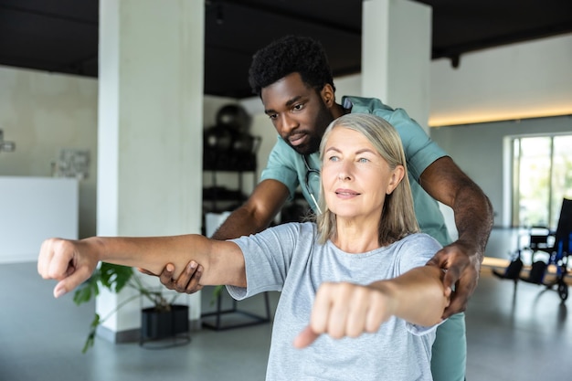 physiotherapist helps adult patient providing physiotherapy rehabilitation arms pain relief 259150 83472